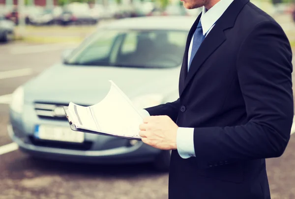 Man with car documents outside — Stock Photo, Image