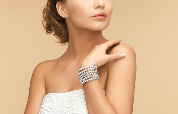 Mujer con pendientes de perlas y pulsera — Foto de Stock