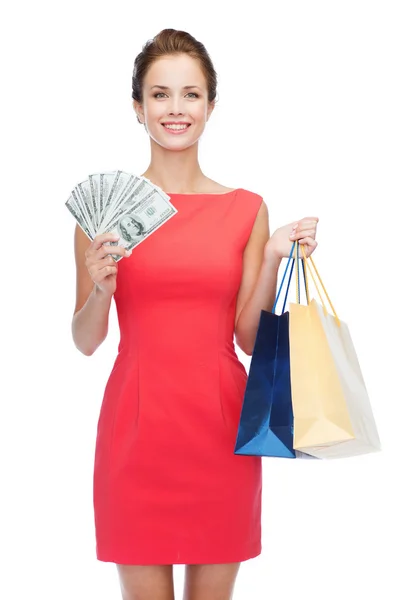 Smiling elegant woman in dress with shopping bags — Stock Photo, Image