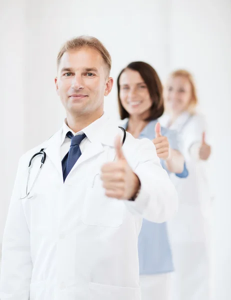 Doctor with stethoscope and colleagues — Stock Photo, Image