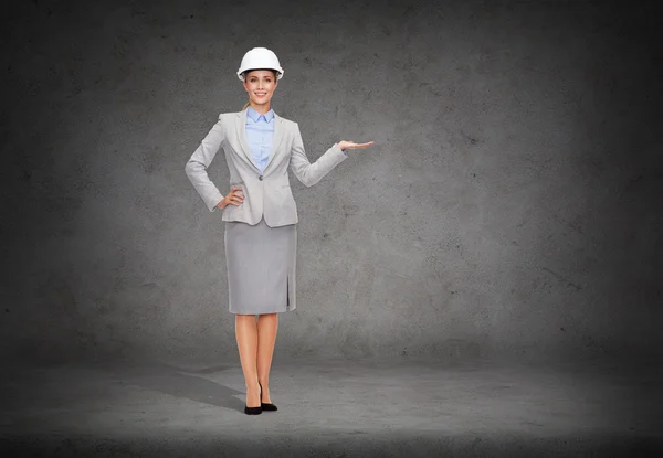 Mulher de negócios no capacete segurando algo na palma da mão — Fotografia de Stock