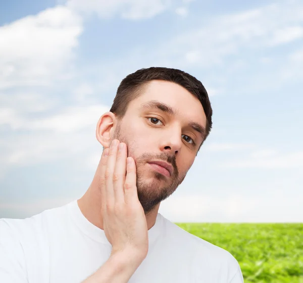 Beautiful calm man touching his face — Stock Photo, Image