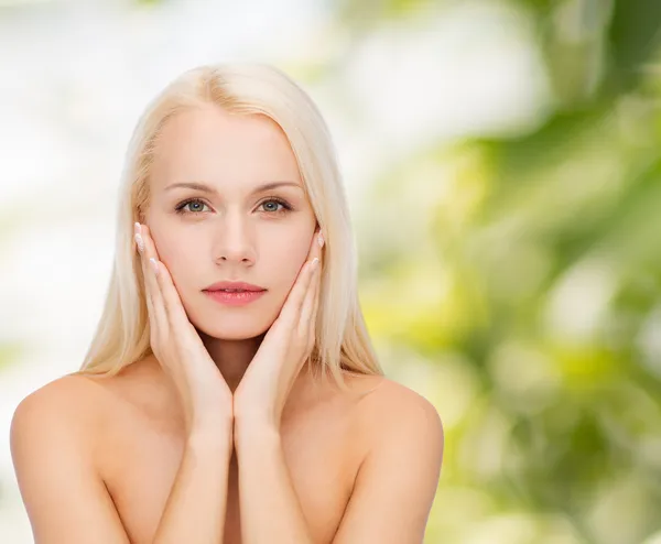 Volto di bella donna che tocca la sua pelle del viso — Foto Stock