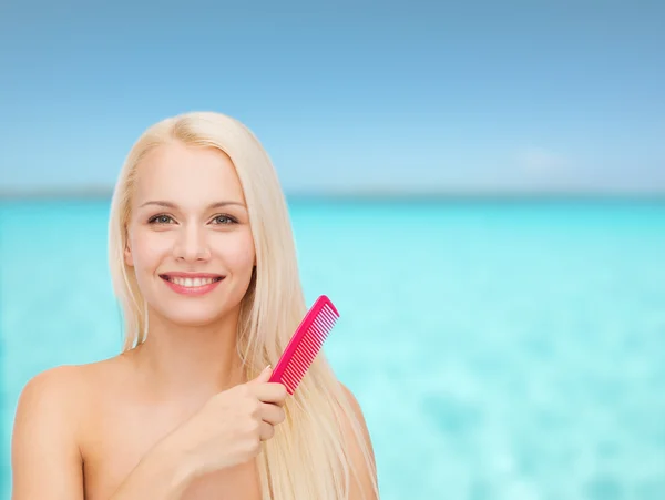 Femme souriante avec brosse à cheveux — Photo