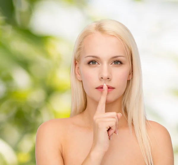 Jovem mulher calma com o dedo nos lábios — Fotografia de Stock