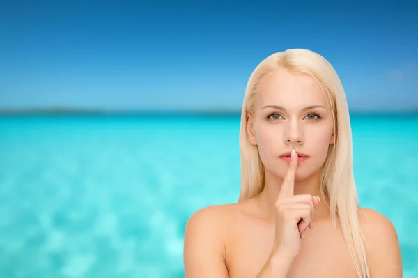 Спокойная молодая женщина с пальцем на губах — стоковое фото