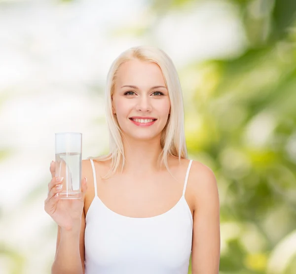 Młoda kobieta uśmiechający się z szklanką wody — Zdjęcie stockowe