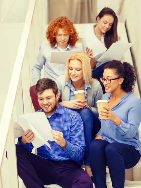 Team mit Papieren und Kaffee zum Mitnehmen im Treppenhaus — Stockfoto