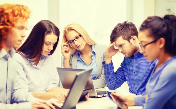 Equipo deprimido con computadoras portátiles y de mesa PC — Foto de Stock