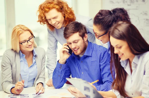 Equipo creativo con papeles y portapapeles en la oficina — Foto de Stock