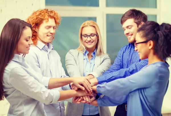 Team mit übereinander hängenden Händen im Amt — Stockfoto