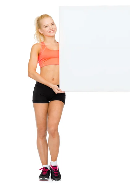 Smiling sportswoman with white blank board — Stock Photo, Image