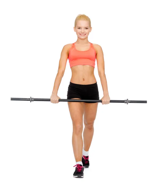 Glimlachende sportieve vrouw oefenen met lange halter — Stockfoto