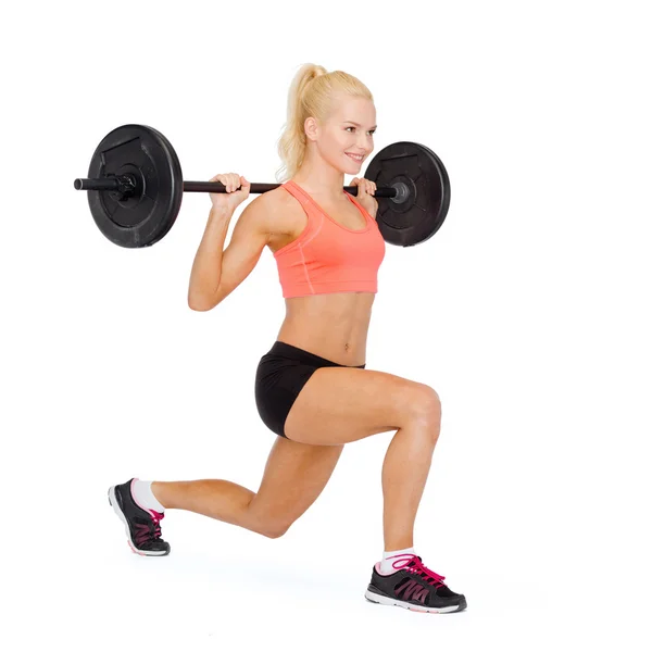 Smiling sporty woman exercising with barbell — Stock Photo, Image