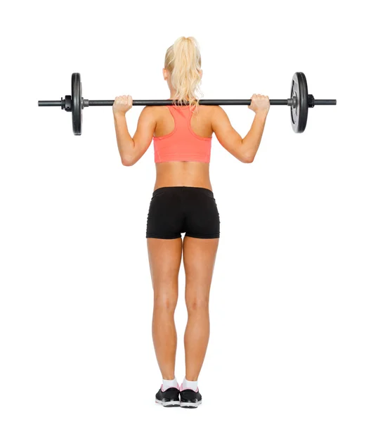 Sporty woman exercising with barbell from the back — Stock Photo, Image