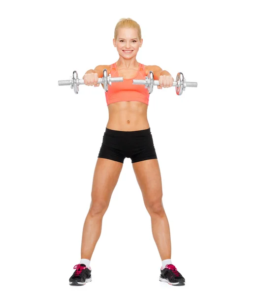 Sorrindo mulher desportiva com halteres de aço pesado — Fotografia de Stock