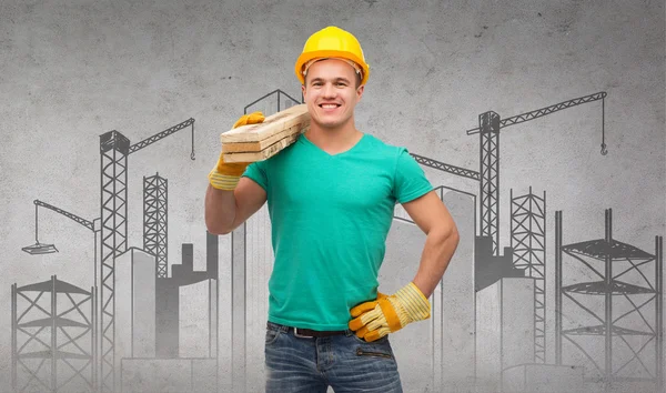 Trabajador manual sonriente en casco con tablas de madera — Foto de Stock