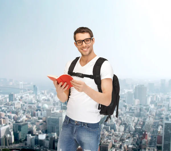 Studente viaggiante con zaino e libro — Foto Stock