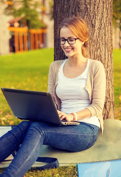 Smiling teenager in eyeglasses with laptop Royalty Free Stock Photos