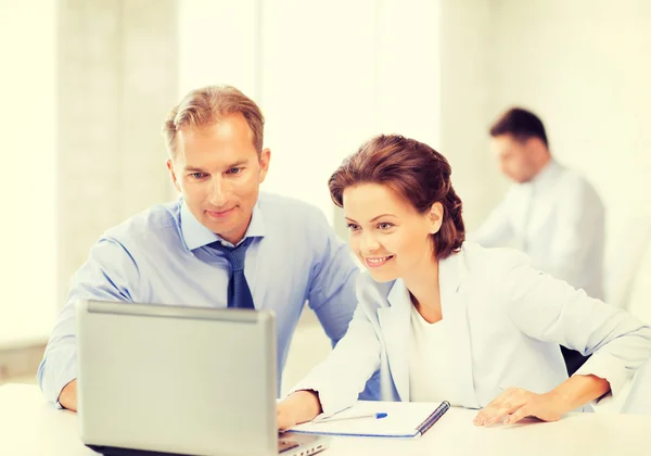 Homme et femme travaillant avec un ordinateur portable au bureau — Photo