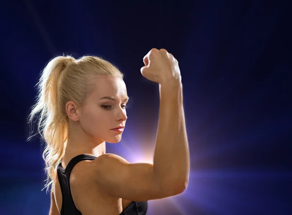 Primo piano della donna atletica flettendo i bicipiti — Foto Stock