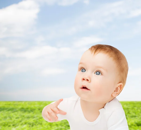 Nieuwsgierig baby liggend op vloer en opzoeken — Stockfoto