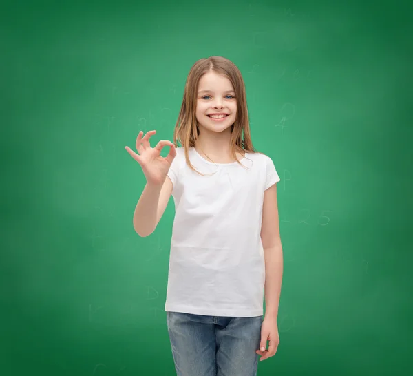 Bambina in t-shirt bianca mostrando gesto ok — Foto Stock