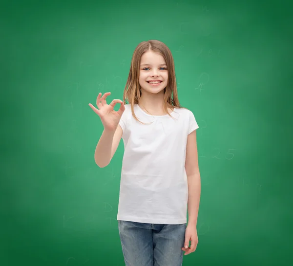 Menina em branco t-shirt mostrando ok gesto — Fotografia de Stock