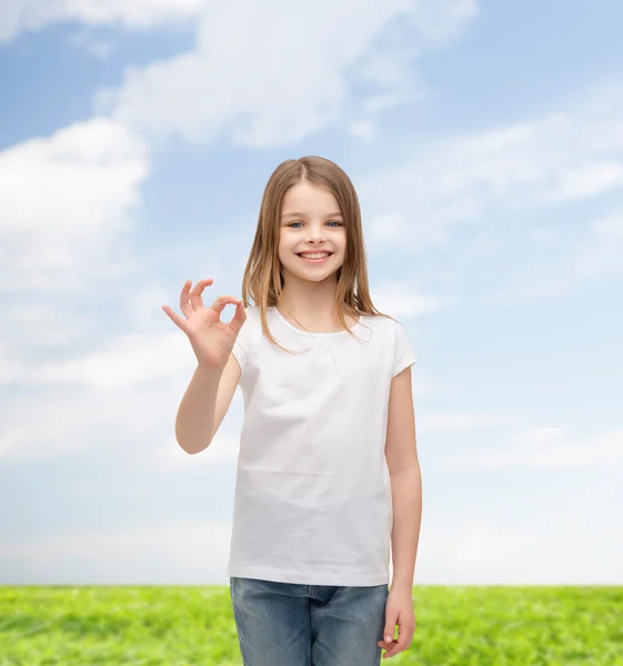 Menina em branco t-shirt mostrando ok gesto — Fotografia de Stock