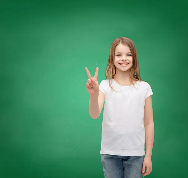 Liten flicka i vit t-shirt visar fred gest — Stockfoto