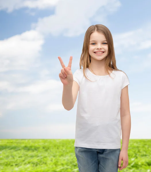 Liten flicka i vit t-shirt visar fred gest — Stockfoto