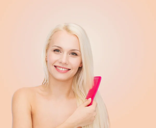 Femme souriante avec brosse à cheveux — Photo