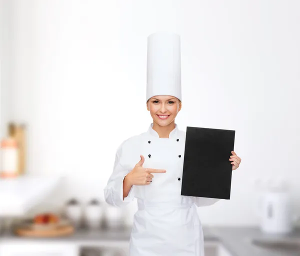 Chef feminino sorridente com papel em branco preto — Fotografia de Stock