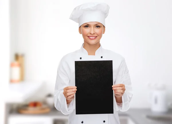 Chef feminino sorridente com papel em branco preto — Fotografia de Stock