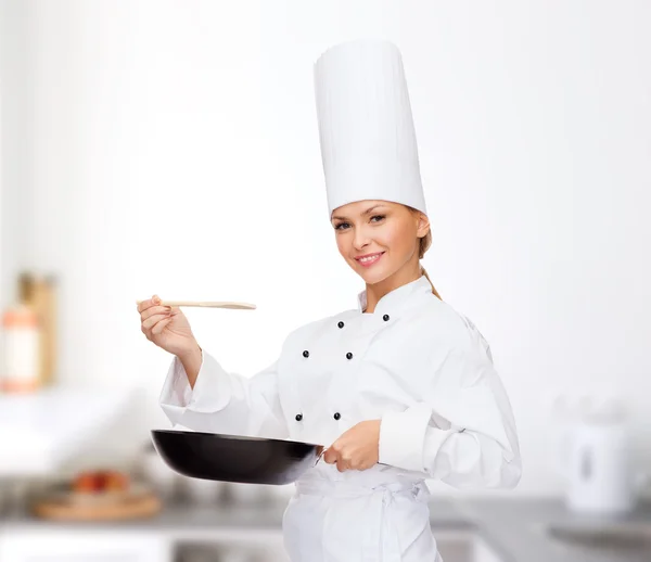 Lachende vrouwelijke chef-kok met pan- en -lepel — Stockfoto