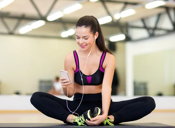 Lächelnde Frau dehnt sich auf Matte im Fitnessstudio — Stockfoto