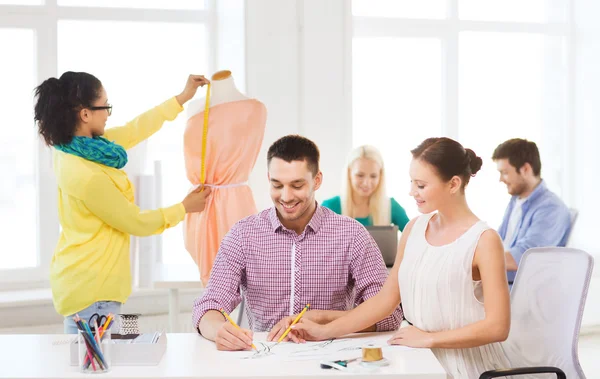 Diseñadores de moda sonrientes trabajando en la oficina — Foto de Stock