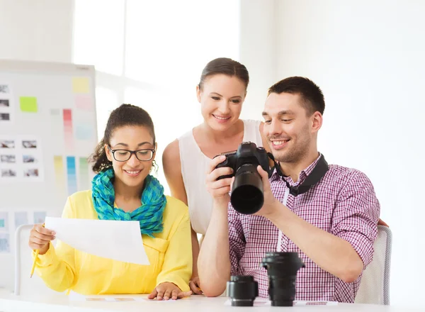 Usměvavý tým s fotokamery pracující v kanceláři — Stock fotografie