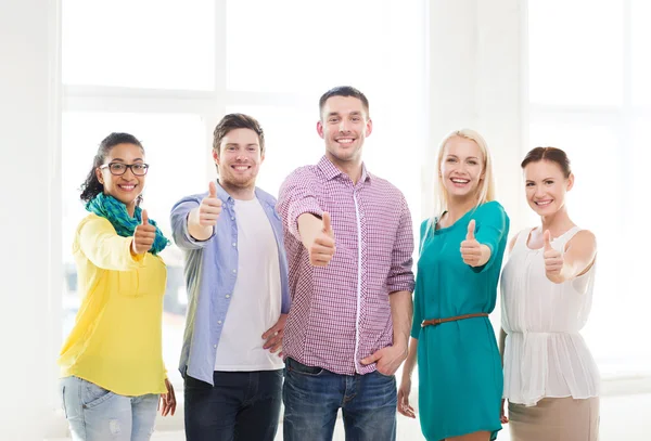 Gelukkig creatieve team duimen opdagen in office — Stockfoto