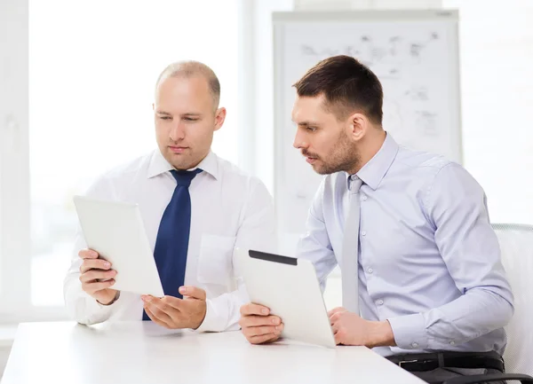 Dos hombres de negocios serios con la tableta PC en la oficina — Foto de Stock