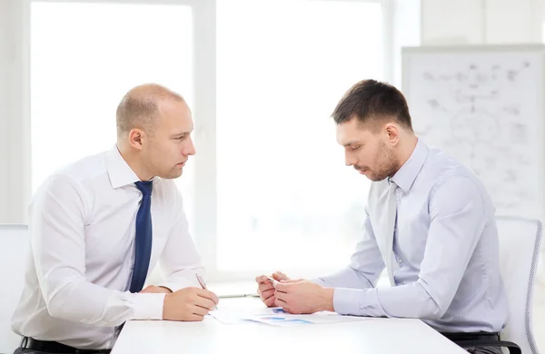 Zwei seriöse Geschäftsleute mit Papieren im Amt — Stockfoto