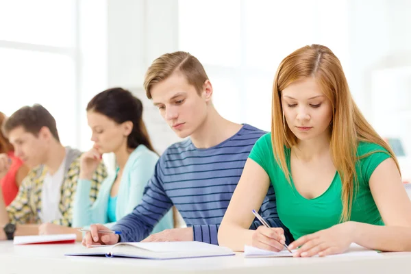 Tired students with textbooks and books at school — Stock Photo, Image