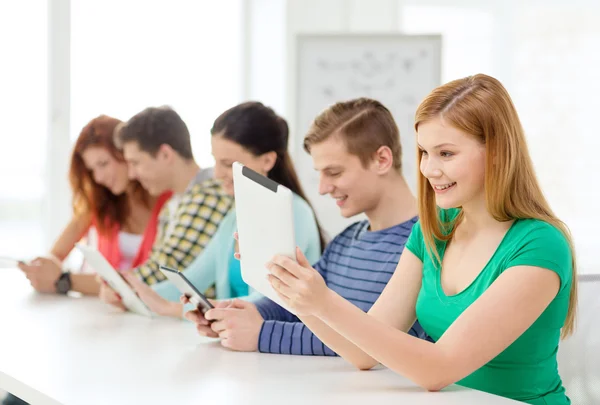 Lachende studenten met de tablet pc op school — Stockfoto