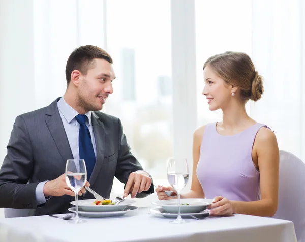 Pareja sonriente comiendo aperitivos en el restaurante — Foto de Stock