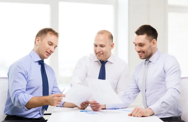 Hommes d'affaires souriants avec des papiers au bureau — Photo