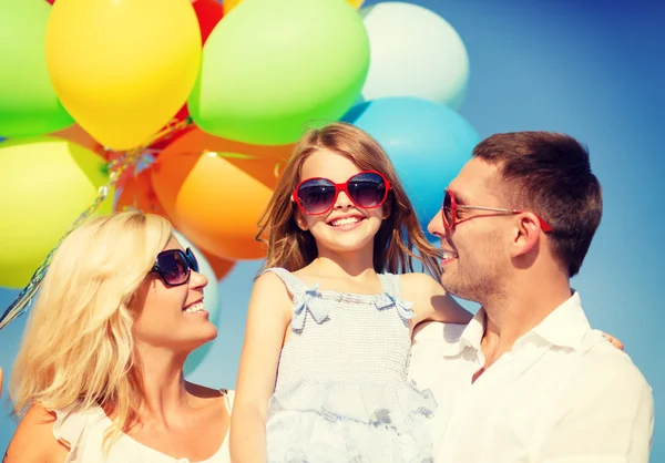 Família feliz com balões coloridos ao ar livre — Fotografia de Stock