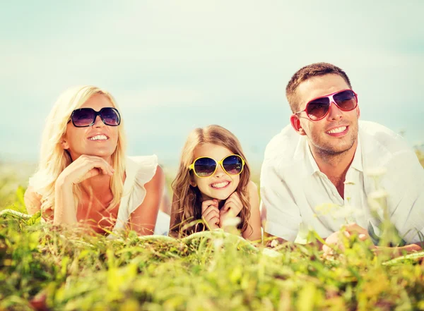 Счастливая семья с голубым небом и зеленой травой — стоковое фото
