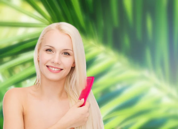 Lächelnde Frau mit Haarbürste — Stockfoto