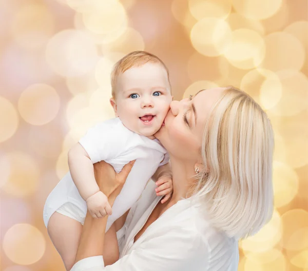 Mãe feliz beijando bebê sorridente — Fotografia de Stock