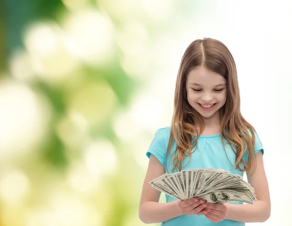 Sorridente bambina guardando denaro contante dollaro — Foto Stock